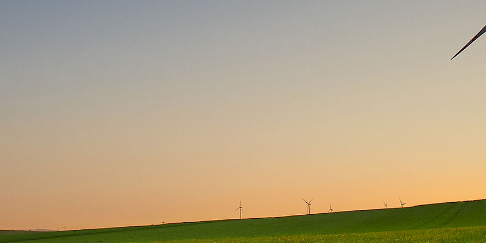 Ein Windrad auf einer grünen leeren Wiese