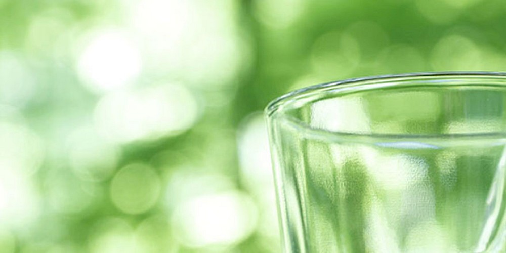 Trinkwasser wird in ein leeres Glas geschüttet