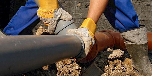 Bauarbeiter montiert Abwasserrohre