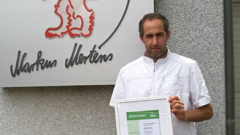 Inhaber Markus Merkens vor seiner Bäckerei mit dem Energieauditzertifikat in seinen Händen
